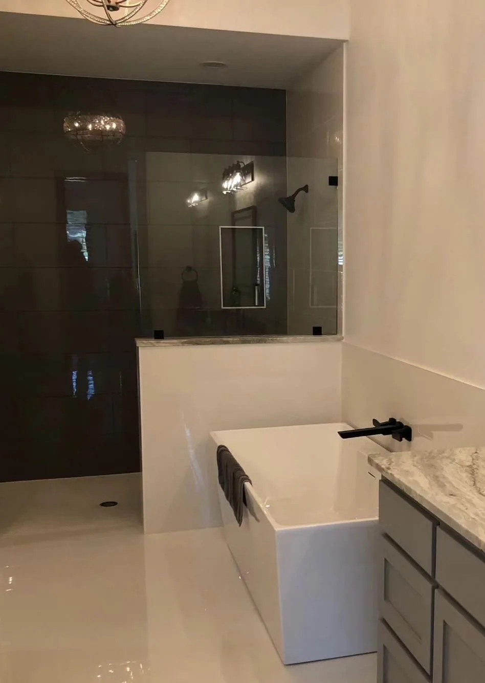 Master bathroom with a glass walk-in shower and a white soaking tub