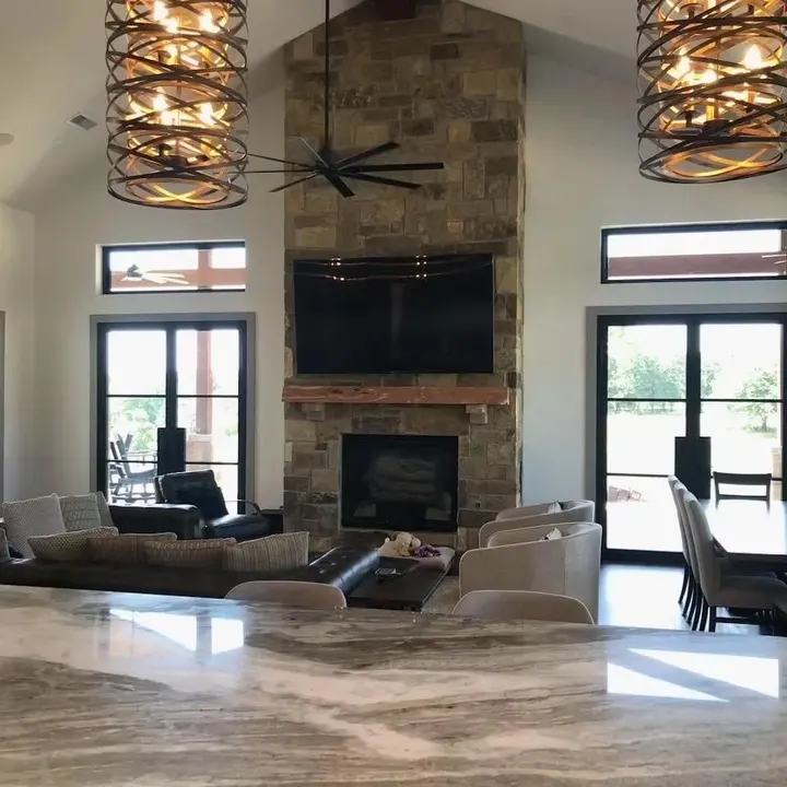 Living room with a stone fireplace, mounted TV and French doors