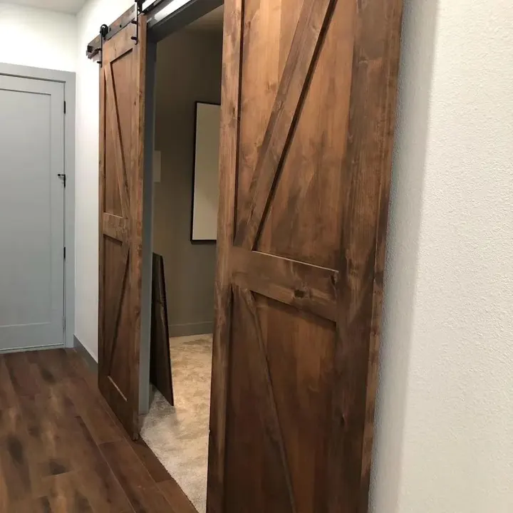Rustic wooden sliding barn door off a hallway