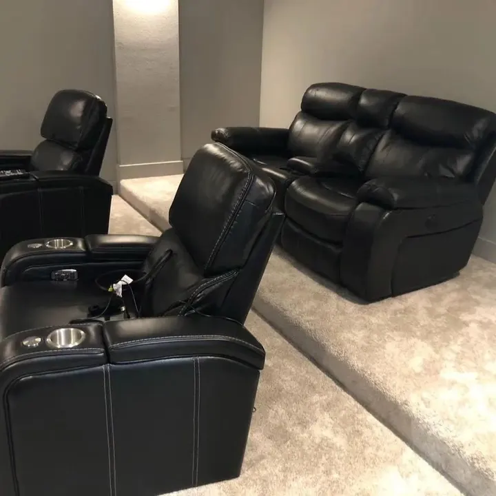 Black leather recliner theater seating on a grey rug